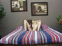 Blondes Girl fickt sich im Bett mit rotem Dildo